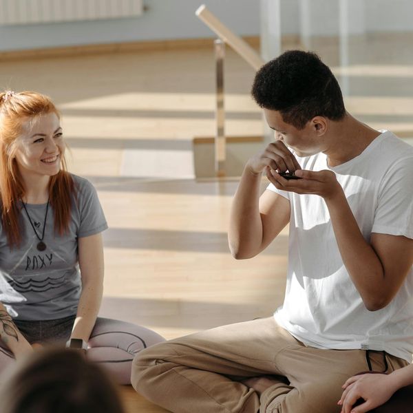 Group of diverse people sitting in a simple yoga pose.